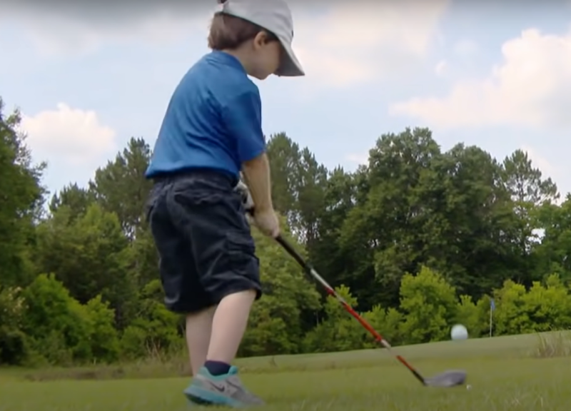 kid plays golf